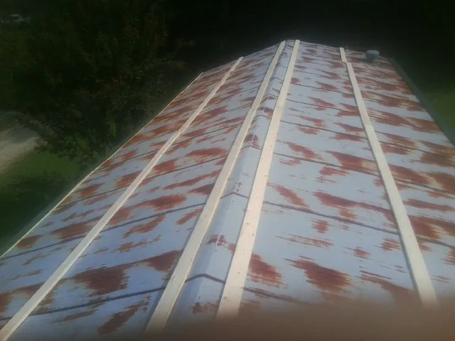 Rusted metal roof panels with new wood purlins before replacement — Storm Damage Roof Repair in West Haven by Roofing Brothers