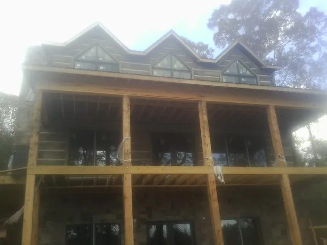 Dormers and porch framing on a large log home under construction — Roof Coating work by our crew in West Haven